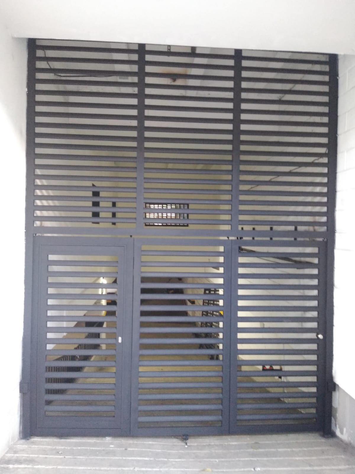 Cerramiento metálico en celosía con puerta peatonal