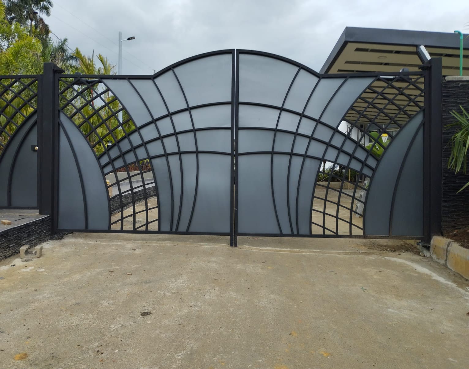 Portón batiente de acero con diseño en abanico, hecho por Puertas S&M