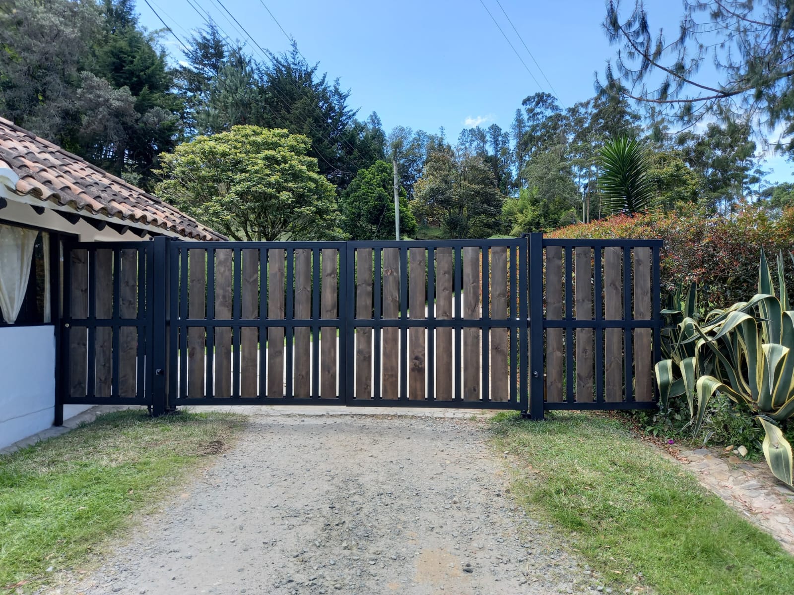 Portón de madera instalado en el acceso de una finca