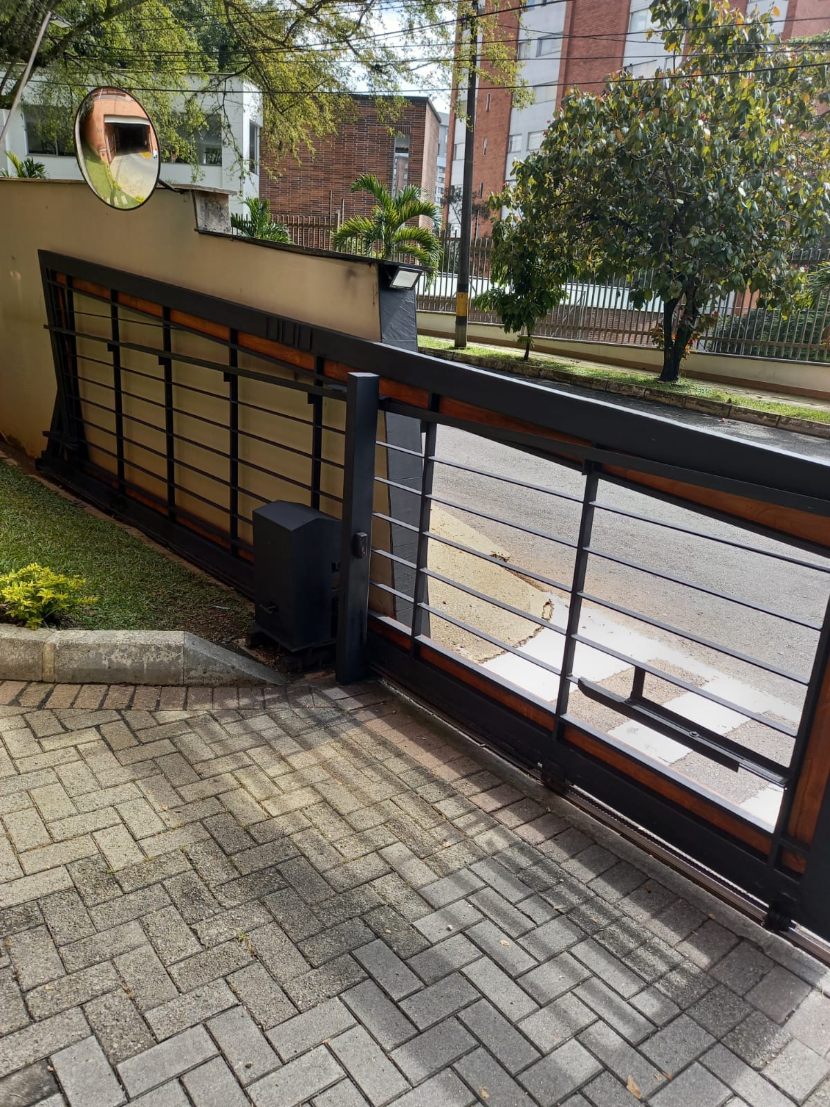 Portón corredizo de acero y madera con motor, en una casa
